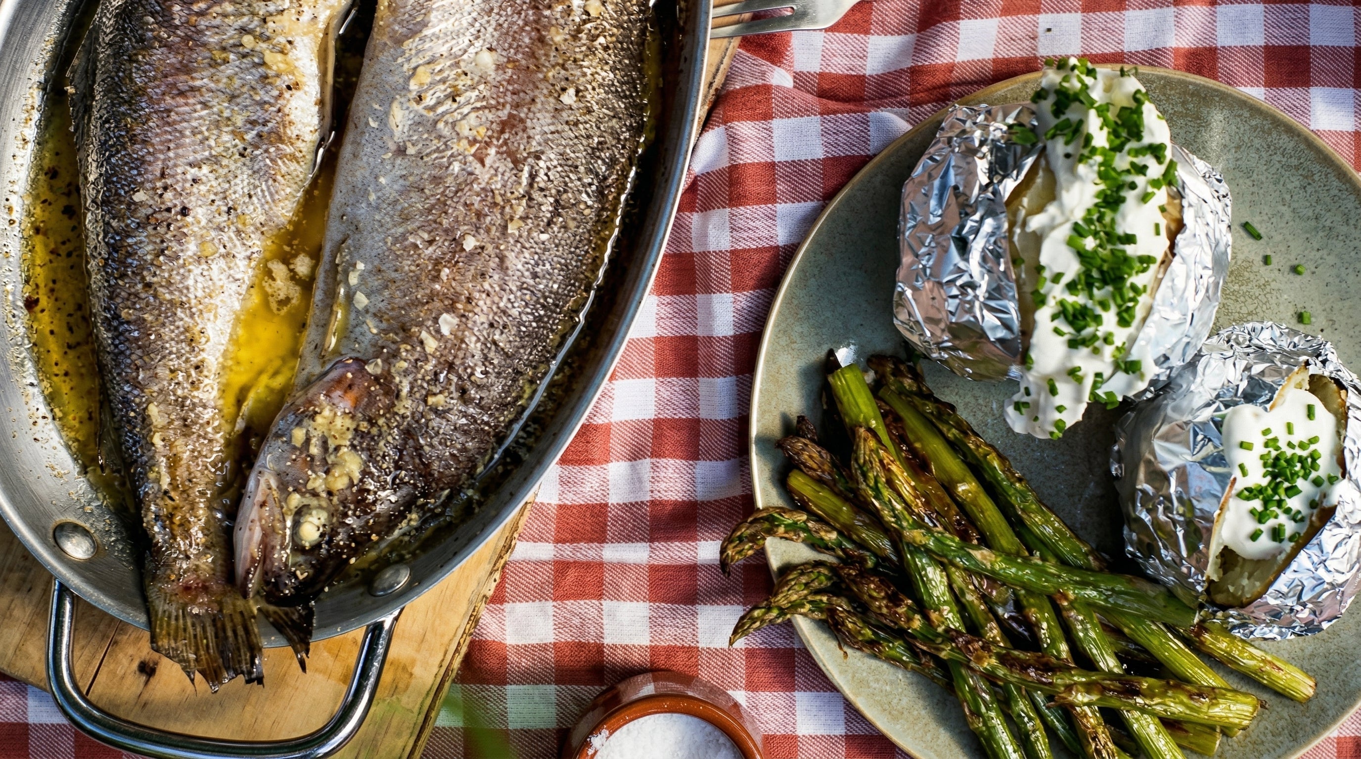 Baked trout, jacket potatoes and grilled asparagus